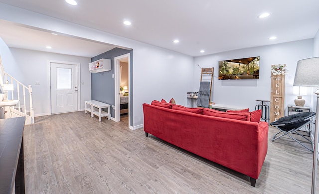 living room featuring light wood-type flooring, stairway, and recessed lighting