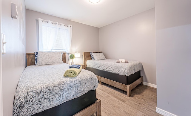 bedroom featuring light wood-style floors and baseboards