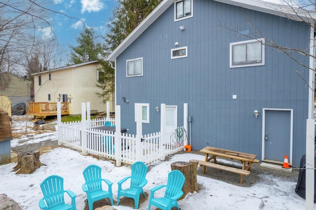 snow covered property with fence and a patio