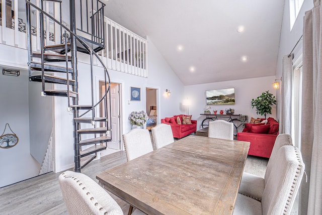 dining space with high vaulted ceiling, stairway, wood finished floors, and recessed lighting