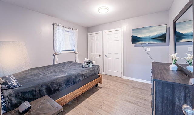 bedroom with light wood-type flooring and baseboards