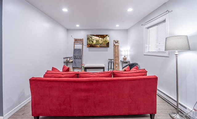 living area with a baseboard heating unit, baseboards, wood finished floors, and recessed lighting