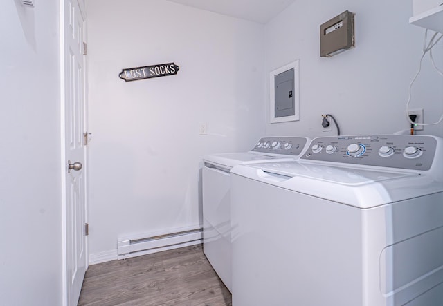 laundry room with a baseboard radiator, wood finished floors, washer and dryer, laundry area, and electric panel