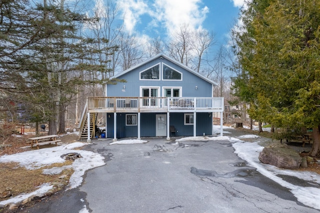 view of front facade with an outdoor fire pit, a wooden deck, and stairs