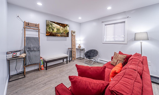 living room featuring a baseboard radiator, wood finished floors, and recessed lighting