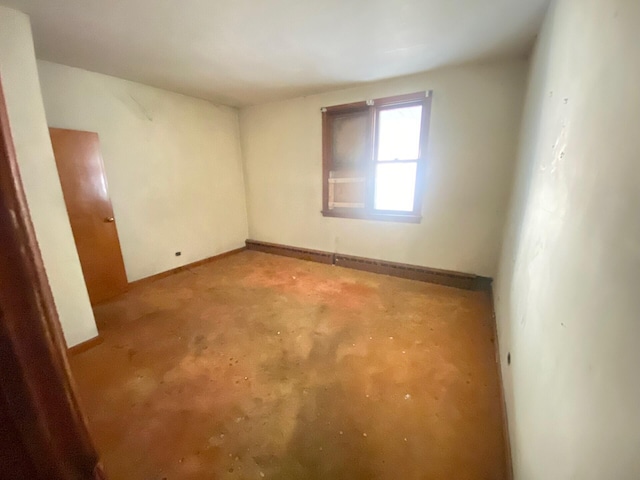 unfurnished room with baseboards