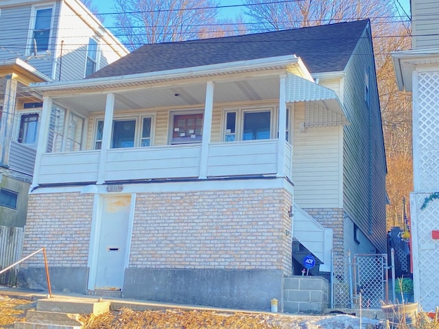 view of home's exterior with roof with shingles and brick siding