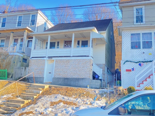 view of front of home with a shingled roof and brick siding