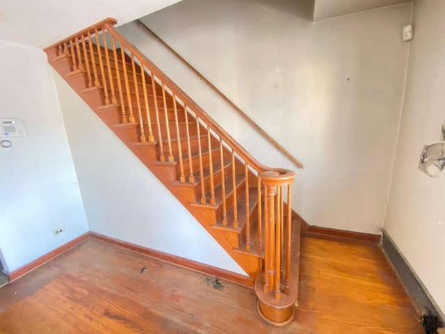 stairway featuring baseboards and wood finished floors