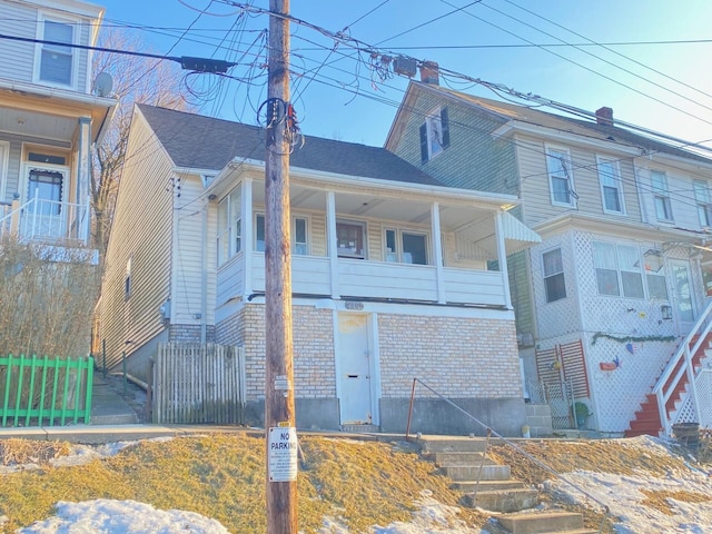 view of front facade with fence and brick siding