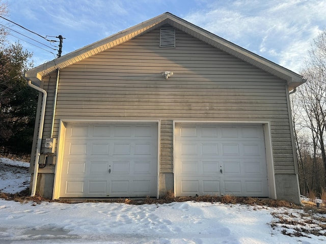 snow covered garage featuring a garage