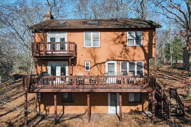 154 Elgin Way, Bushkill, PA 18324 - rear view of house featuring french doors, a wooden deck, a chimney, and a balcony