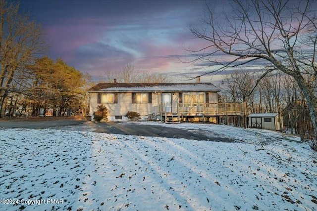 view of front of house featuring a storage shed, a deck, and an outbuilding