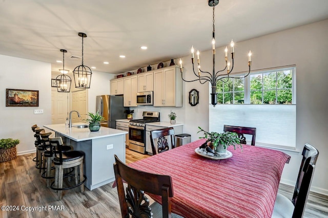 dining room with a notable chandelier, wood finished floors, and baseboards