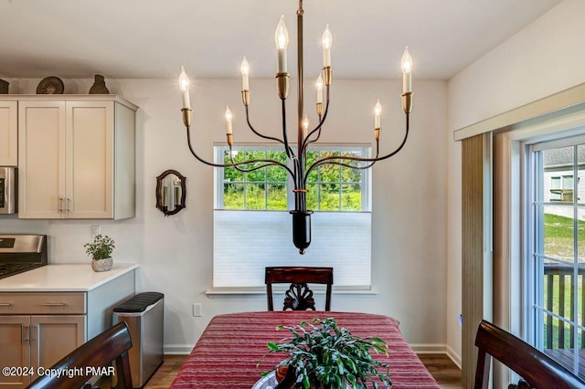 dining area with a chandelier, baseboards, and wood finished floors