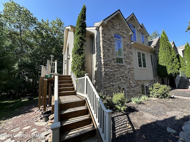 view of front of home featuring stone siding and stairs