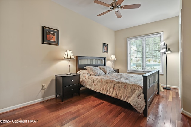 bedroom with dark wood-type flooring, a ceiling fan, and baseboards