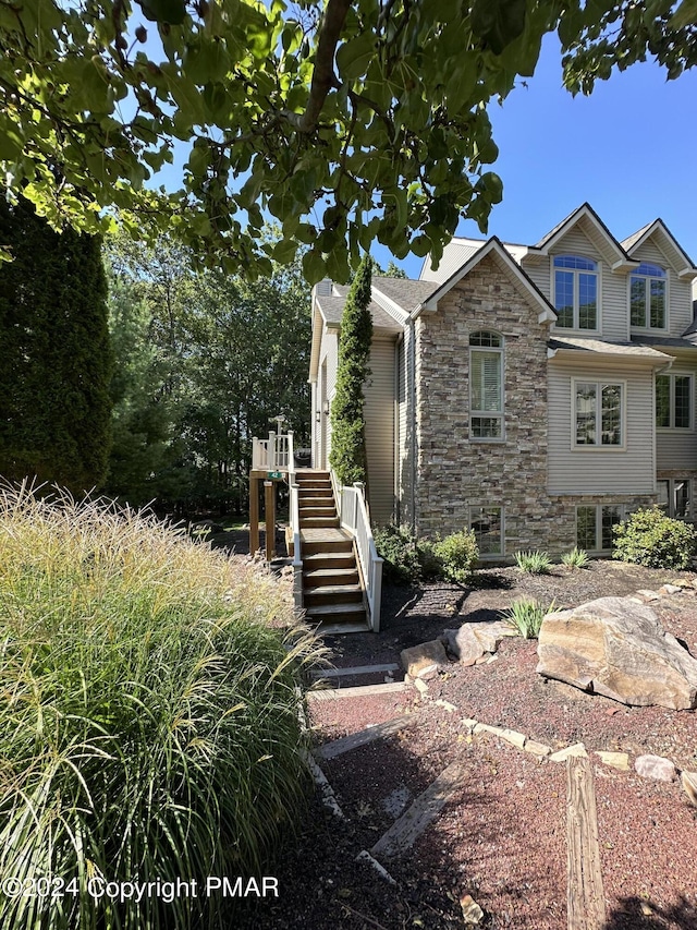 view of front facade with stairs and stone siding