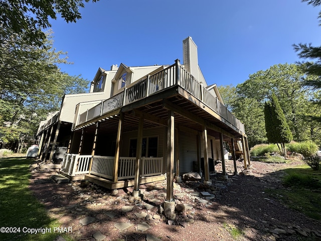 view of property exterior featuring a chimney and a wooden deck