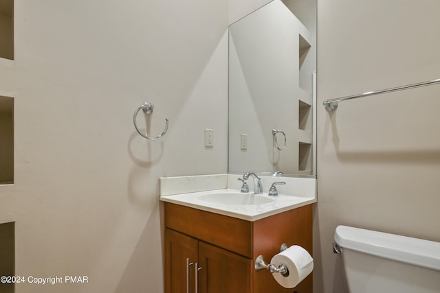 half bathroom with vanity and toilet