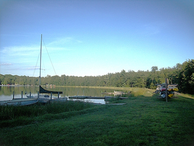 view of dock with a forest view and a water view