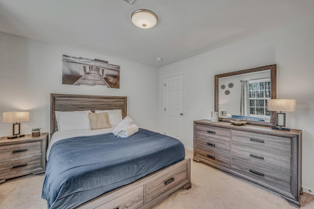 bedroom with light colored carpet and baseboards