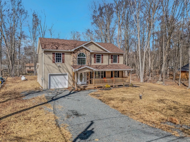 view of front of house featuring roof with shingles, gravel driveway, a porch, an attached garage, and stone siding