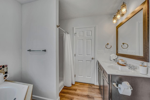 full bathroom with a shower with shower curtain, double vanity, wood finished floors, and a sink