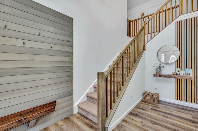 staircase with baseboards and wood finished floors