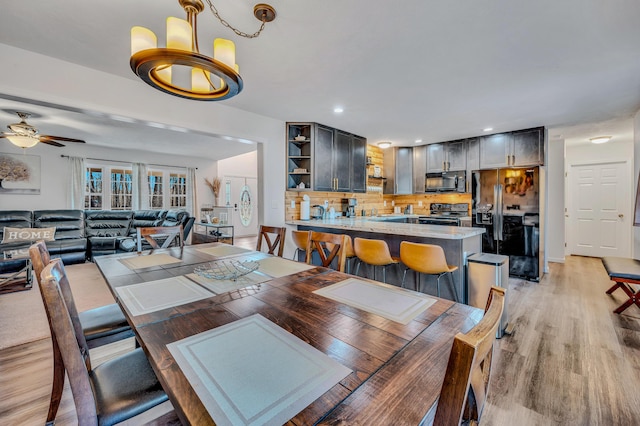 dining space with a ceiling fan, recessed lighting, light wood-style floors, and baseboards