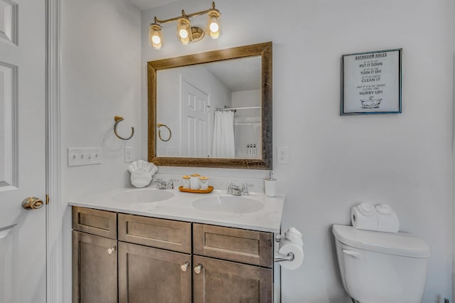 bathroom with double vanity, curtained shower, toilet, and a sink