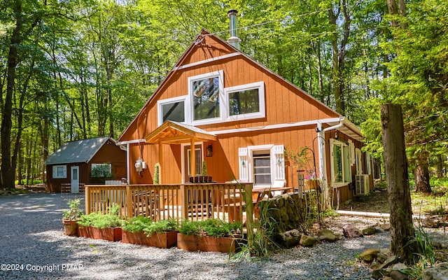 chalet / cabin featuring a forest view and a wooden deck