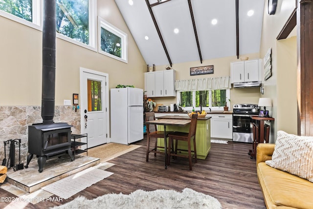 kitchen with stainless steel electric stove, wood-type flooring, white cabinetry, a wood stove, and white refrigerator