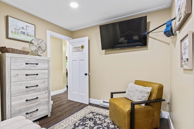 sitting room with dark wood-type flooring and baseboard heating