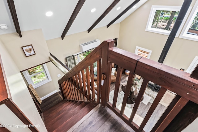 stairway featuring a wall mounted air conditioner, vaulted ceiling with beams, and hardwood / wood-style floors