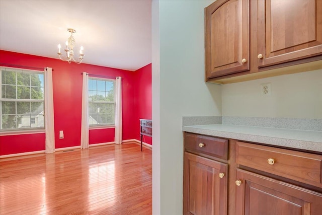 706 Franklin Ct, East Stroudsburg, PA 18302 - kitchen with a chandelier, light countertops, light wood-type flooring, and brown cabinetry
