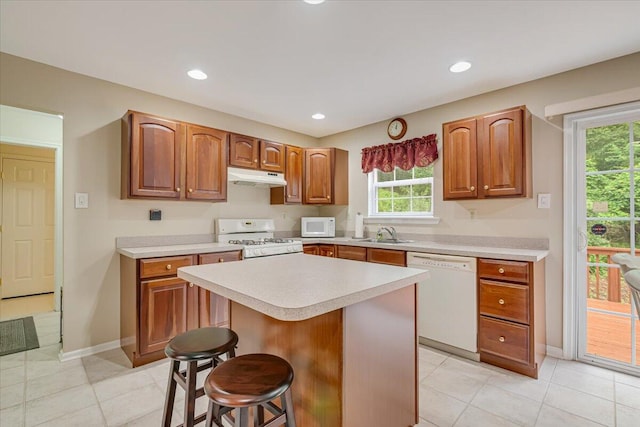 706 Franklin Ct, East Stroudsburg, PA 18302 - kitchen featuring white appliances, under cabinet range hood, light countertops, a breakfast bar area, and a kitchen island