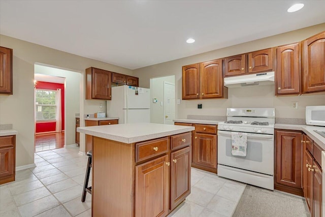 706 Franklin Ct, East Stroudsburg, PA 18302 - kitchen with white appliances, under cabinet range hood, light countertops, a kitchen island, and light tile patterned floors