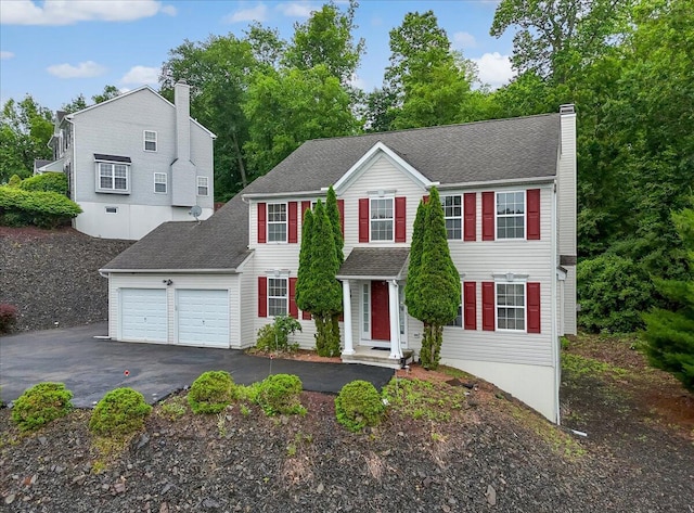 706 Franklin Ct, East Stroudsburg, PA 18302 - view of front of house featuring a chimney, an attached garage, asphalt driveway, and roof with shingles