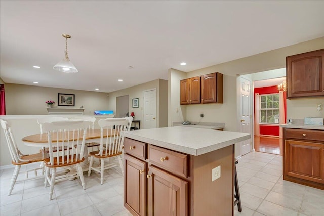 706 Franklin Ct, East Stroudsburg, PA 18302 - kitchen with light countertops, a kitchen island, light tile patterned floors, hanging light fixtures, and brown cabinetry