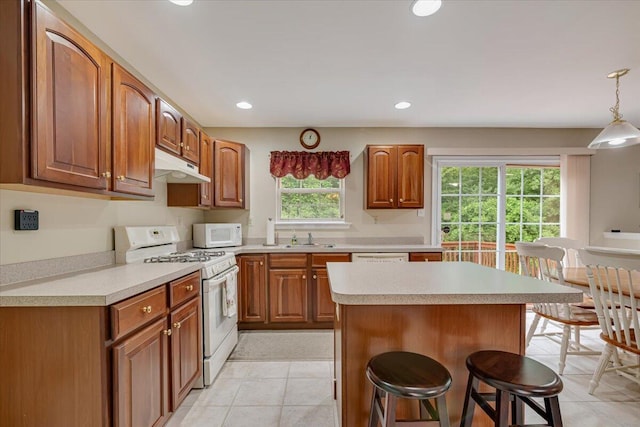 706 Franklin Ct, East Stroudsburg, PA 18302 - kitchen featuring white appliances, under cabinet range hood, a breakfast bar area, light tile patterned floors, and light countertops