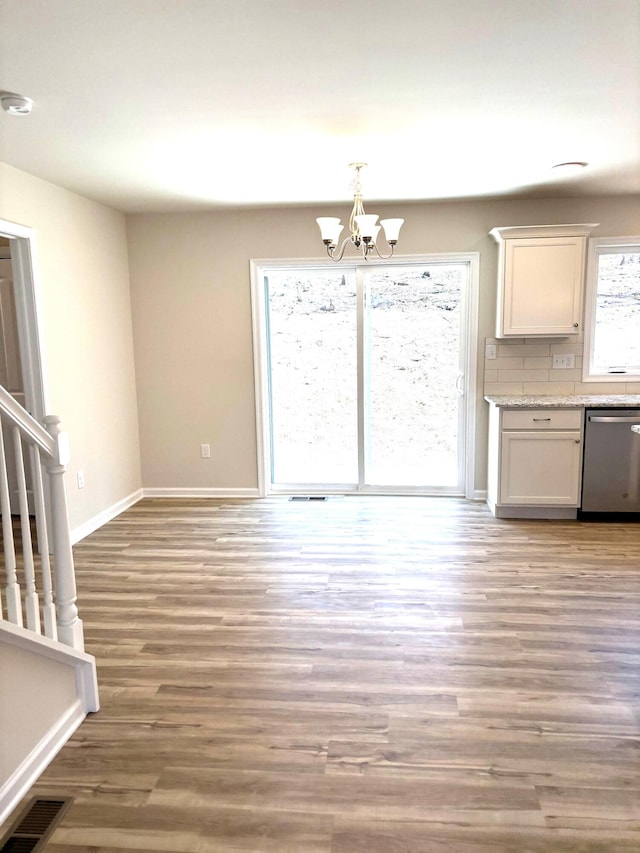 20 Leaf Ct, East Stroudsburg, PA 18302 - unfurnished dining area featuring stairway, wood finished floors, a chandelier, and baseboards