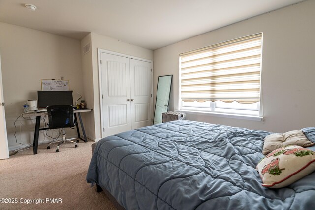 carpeted bedroom featuring visible vents and a closet