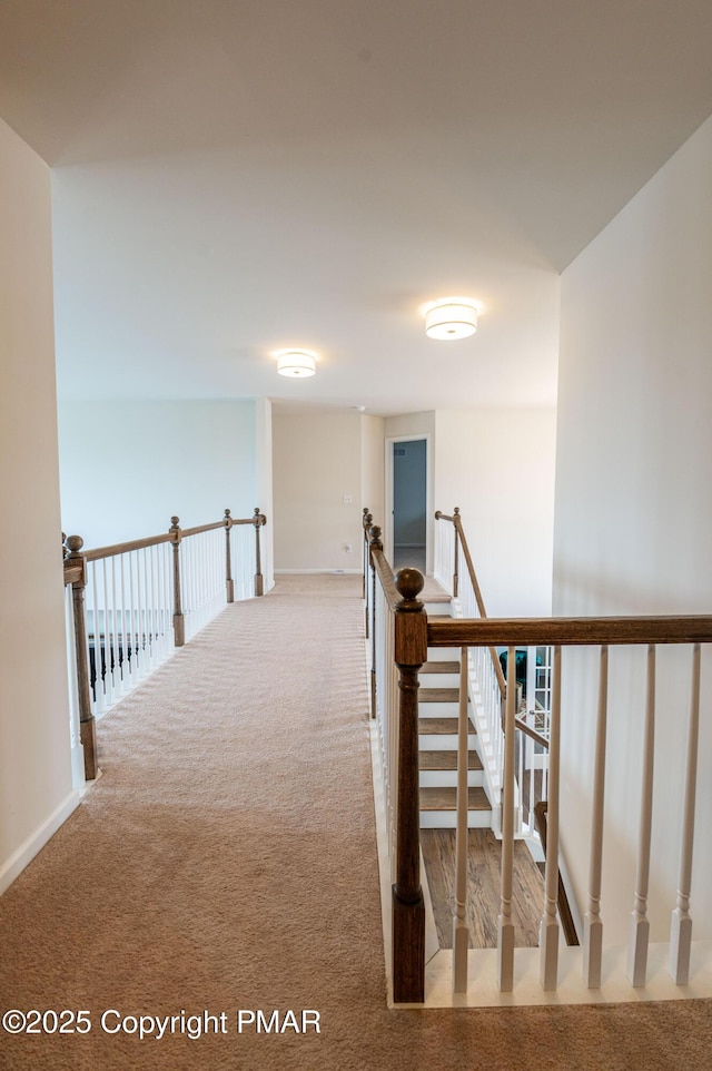 hallway featuring carpet floors and an upstairs landing