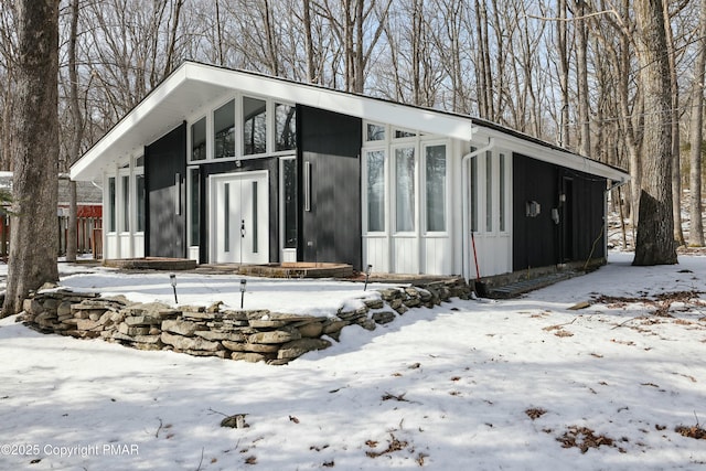 view of snow covered exterior featuring board and batten siding