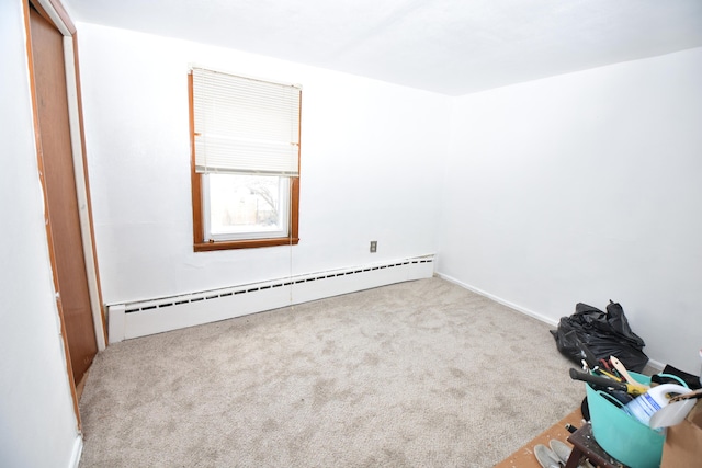 carpeted empty room featuring a baseboard radiator