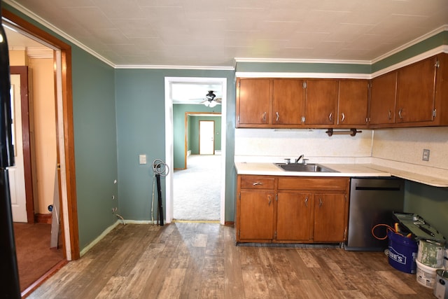 kitchen featuring brown cabinetry, dark wood-type flooring, a sink, and light countertops