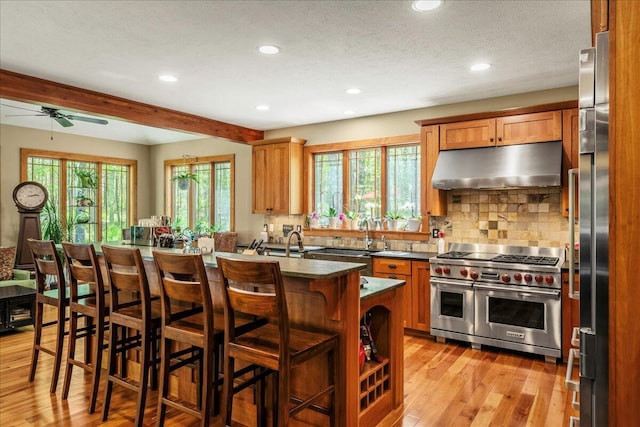 44 Watawga Way W, Gouldsboro, PA 18424 - kitchen featuring under cabinet range hood, double oven range, beamed ceiling, light wood-style flooring, and ceiling fan