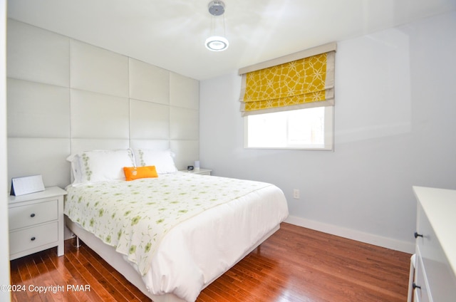 bedroom with dark wood-style floors and baseboards