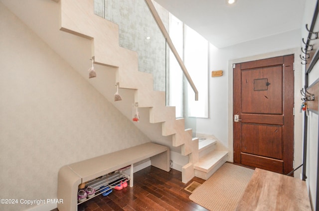 entryway with dark wood-style floors, stairs, and baseboards